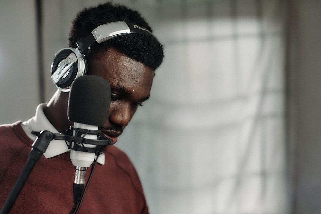 Radio host speaking into a microphone wearing headphones in a studio
