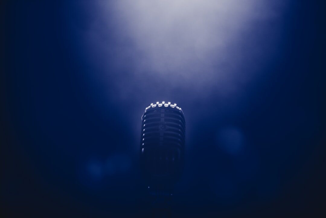 Close-up of a studio microphone under blue stage lighting
