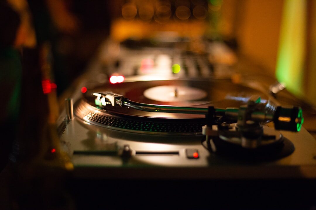 Close-up of a DJ mixer and turntable with warm lighting