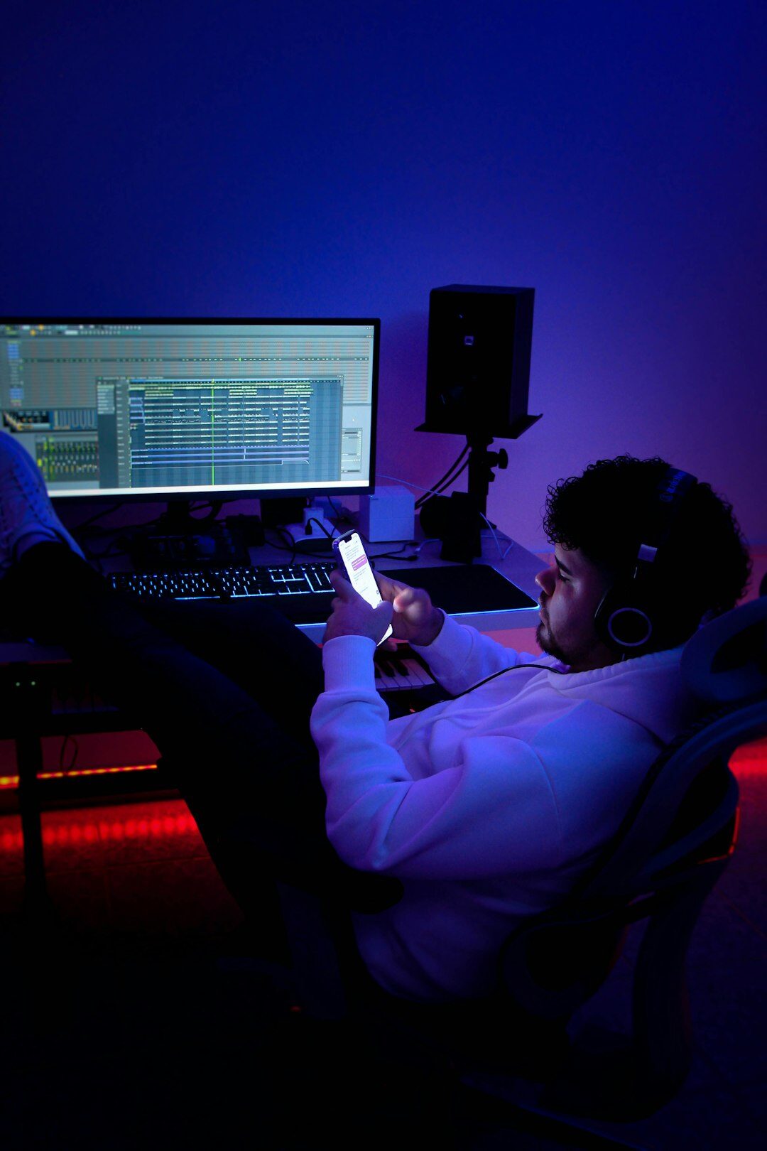 Two colleagues laughing while editing audio together in a studio